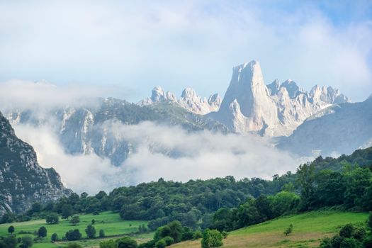 Beautiful mountain landscape with a foggy foreground and lush greenery.