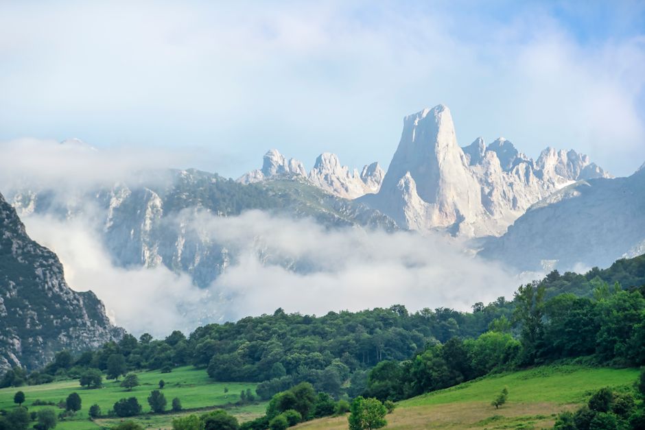 Beautiful mountain landscape with a foggy foreground and lush greenery.