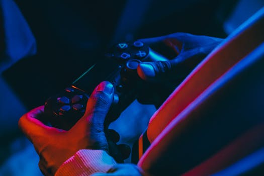 A close-up view of hands holding a gaming controller under colorful lighting, perfect for gaming enthusiasts.