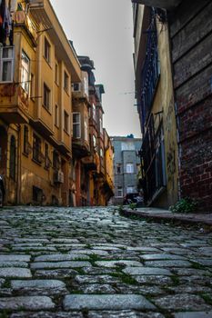 Explore the charm of a cobblestone street in İstanbul's historic district with vibrant architecture.
