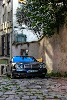 A classic Mercedes parked on a cobblestone street in İstanbul, Turkey with an old building backdrop.