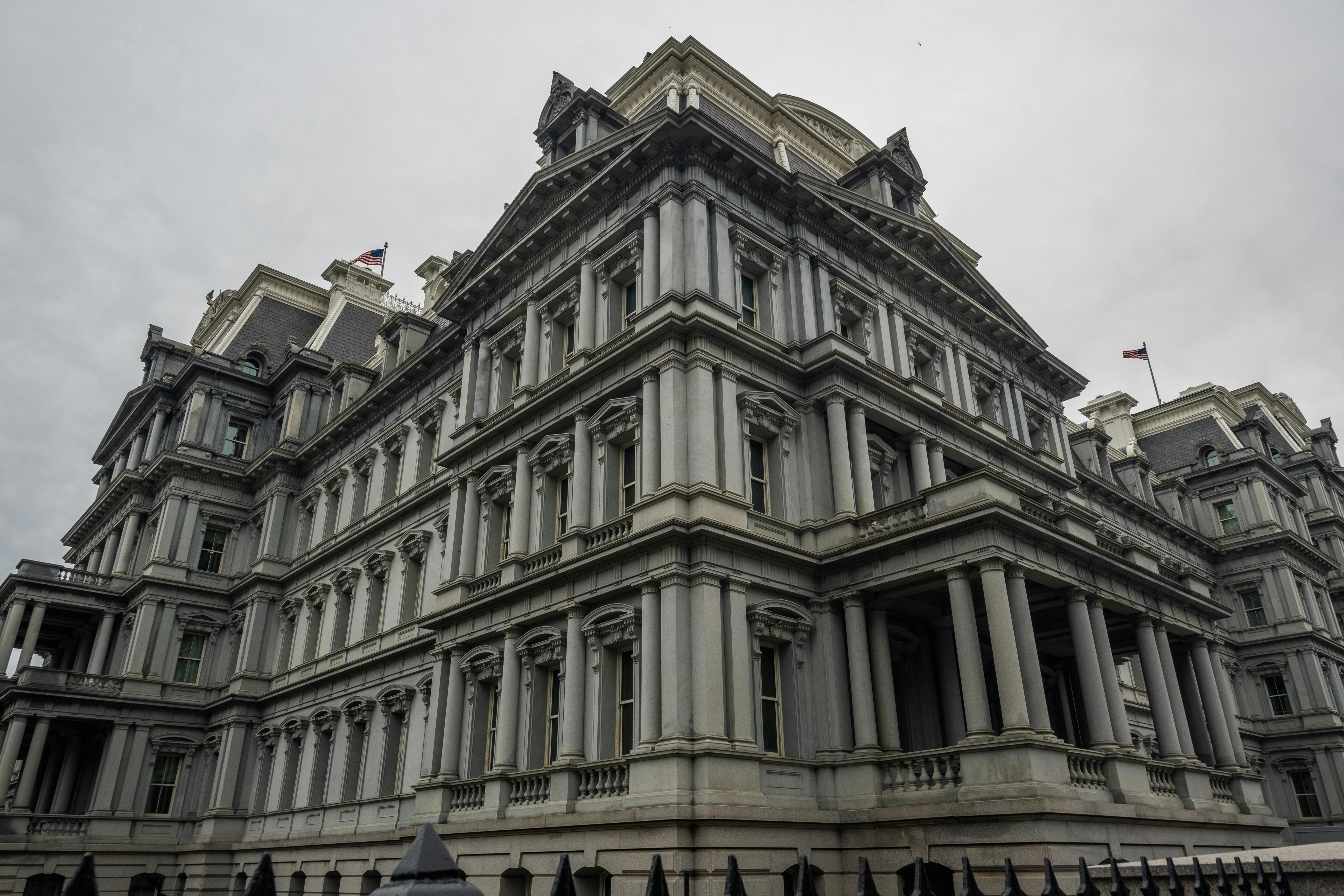 Low angle view of the historic Eisenhower Executive Office Building in Washington, DC, under overcast skies.