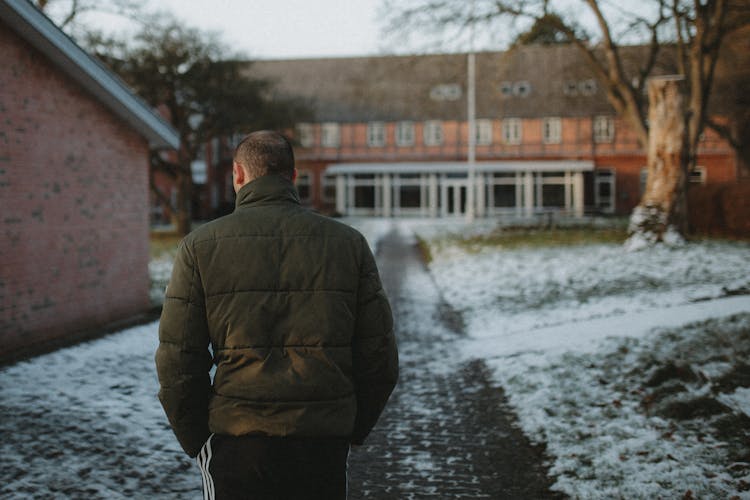 Back View Of A Man Walking On A Pathway During Winter