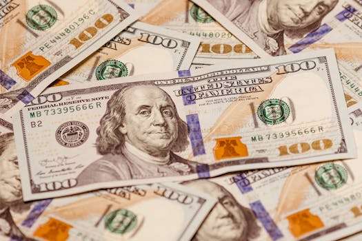 Close-up view of multiple US hundred dollar bills showcasing Benjamin Franklin.