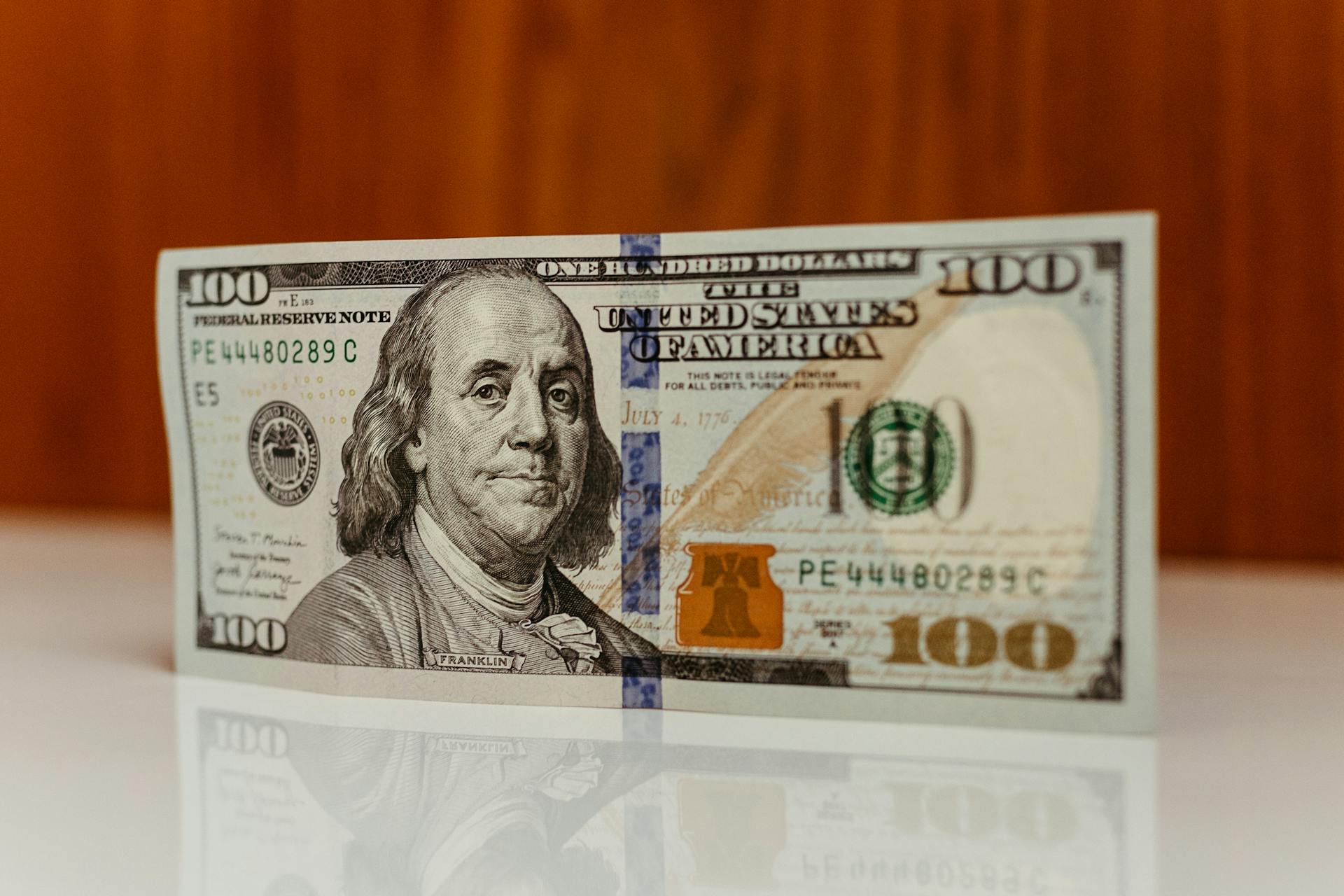 Detailed image of a US one hundred dollar bill featuring Benjamin Franklin.