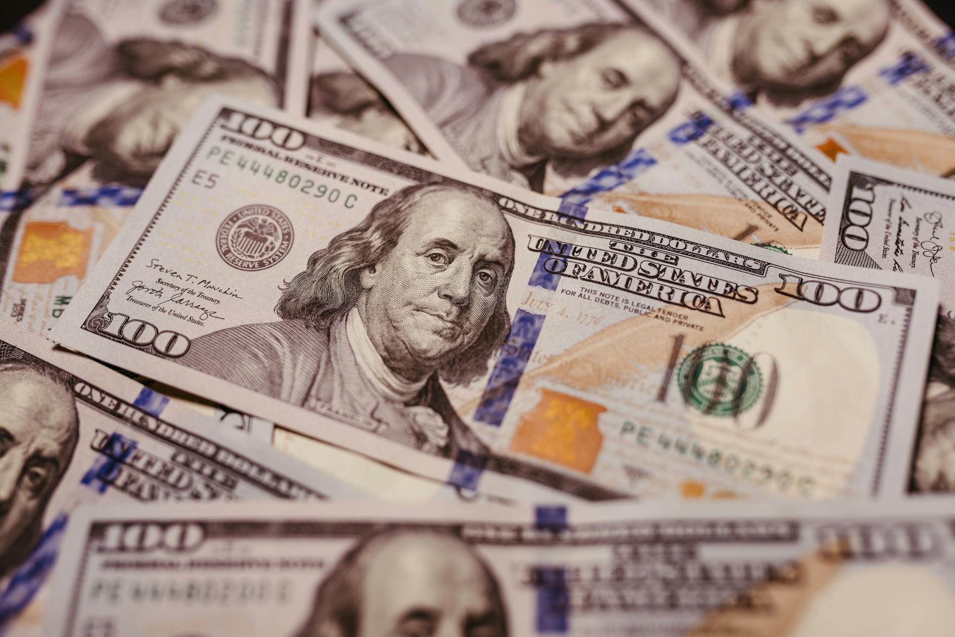 Pile of 100 dollar bills depicting wealth and financial success in close-up view.