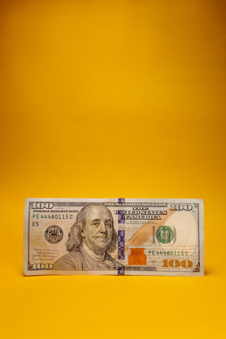 A Dollar Bill On Yellow Background