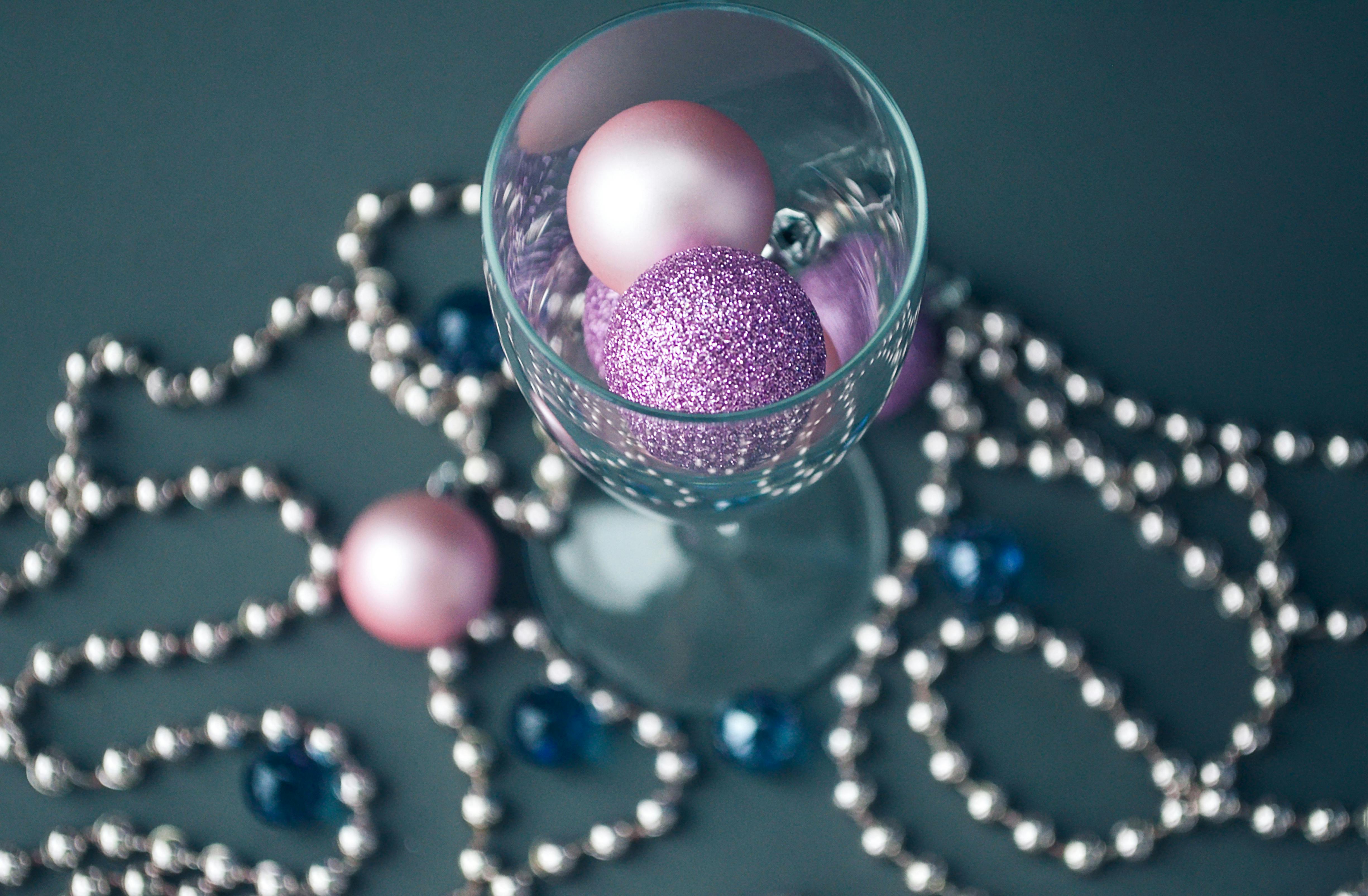 wineglass with pink balls with a string of beads at the base