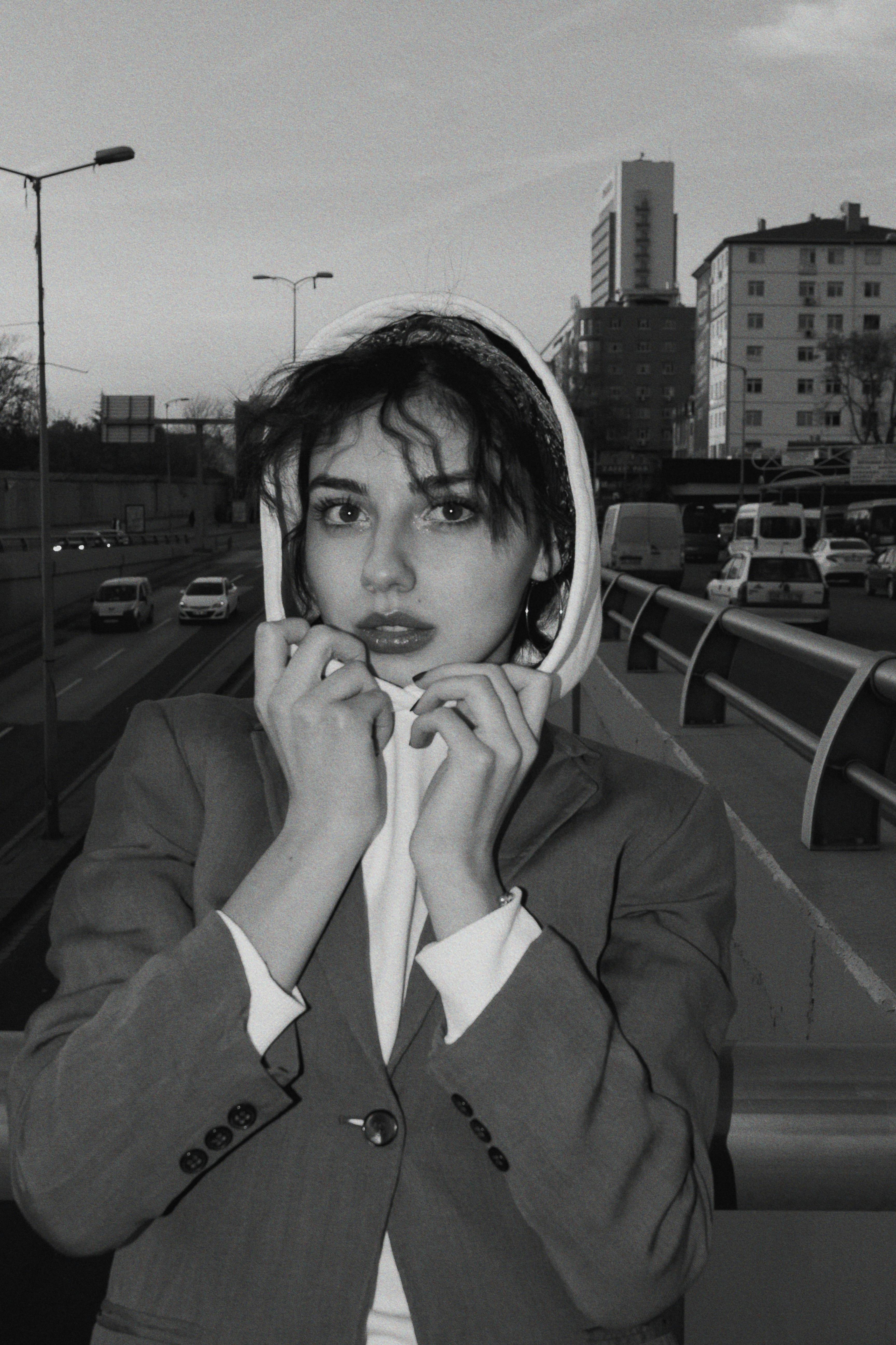 Black and white portrait of a woman in a hoodie on an Ankara street.