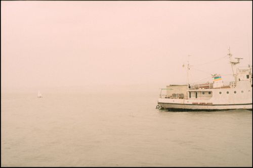 Free A serene ship sailing through misty sea with a foggy horizon, creating a tranquil atmosphere. Stock Photo