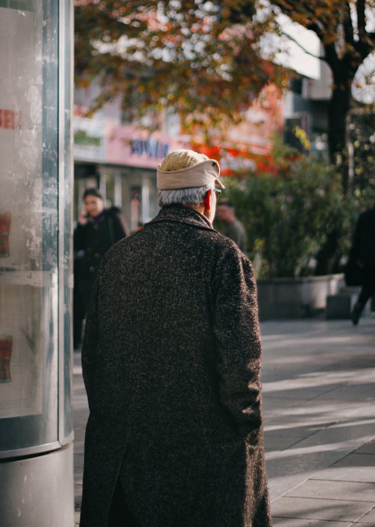 A Man In Black Coat Walking On The Street