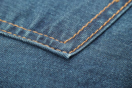 宏观镜头突出了蓝色牛仔面料上复杂的缝线