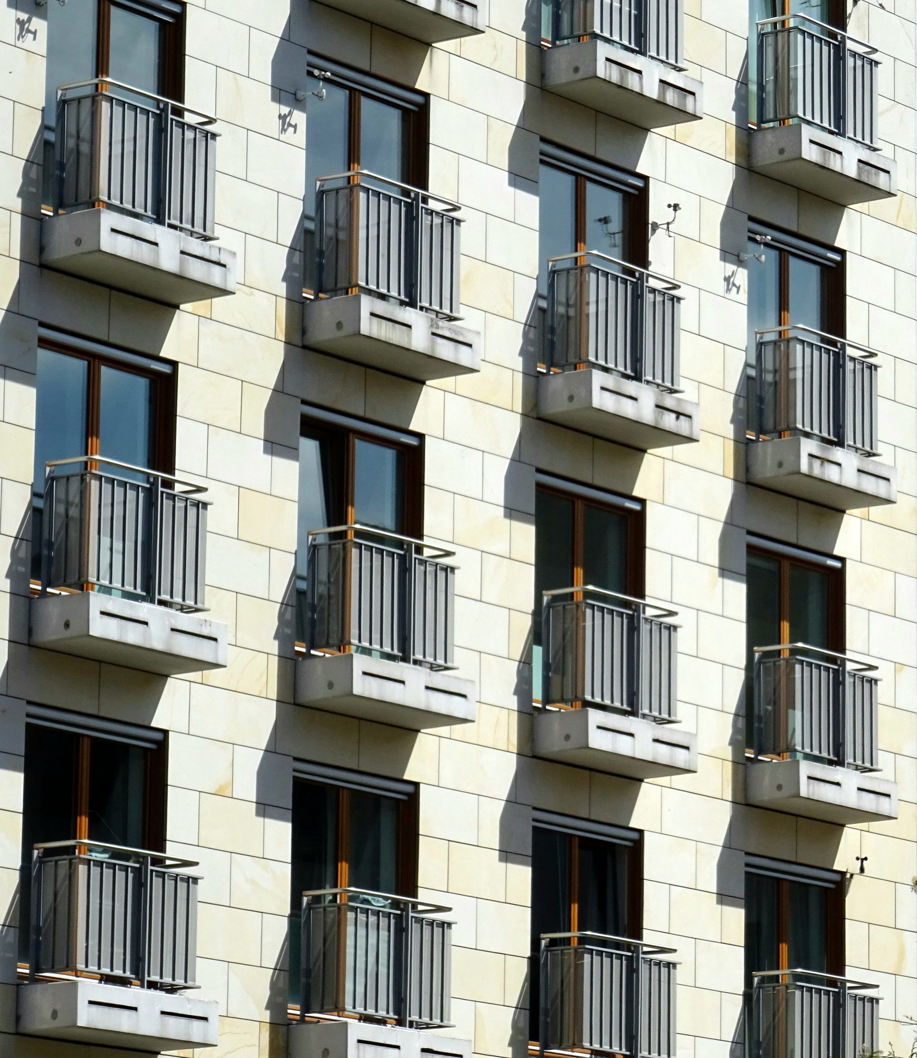Façade de copropriété et garde-corps Façade d'immeuble d'habitation rythmée par de petits balcons et leurs garde-corps métalliques