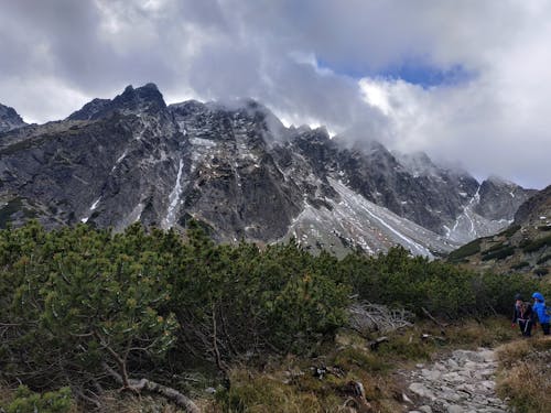 Fotografía De La Naturaleza De Dos Personas De Pie Frente A La Montaña