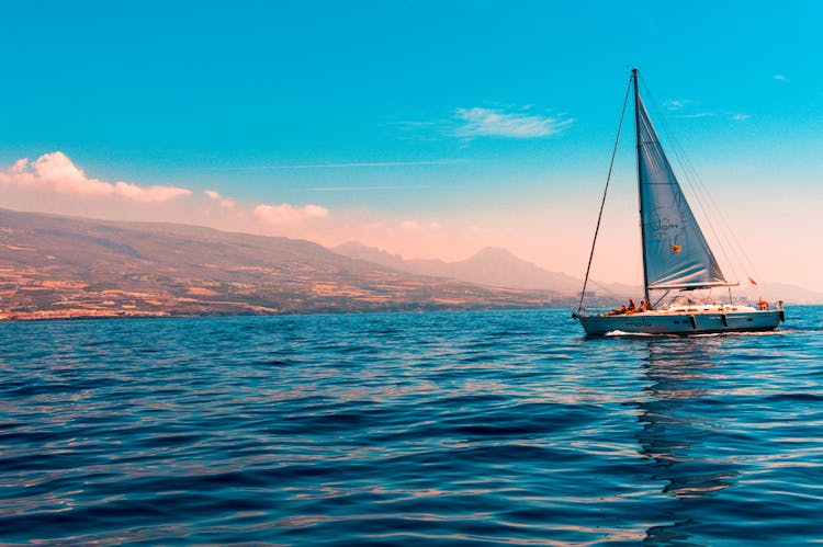 Sailboat Sailing On Water Near Island