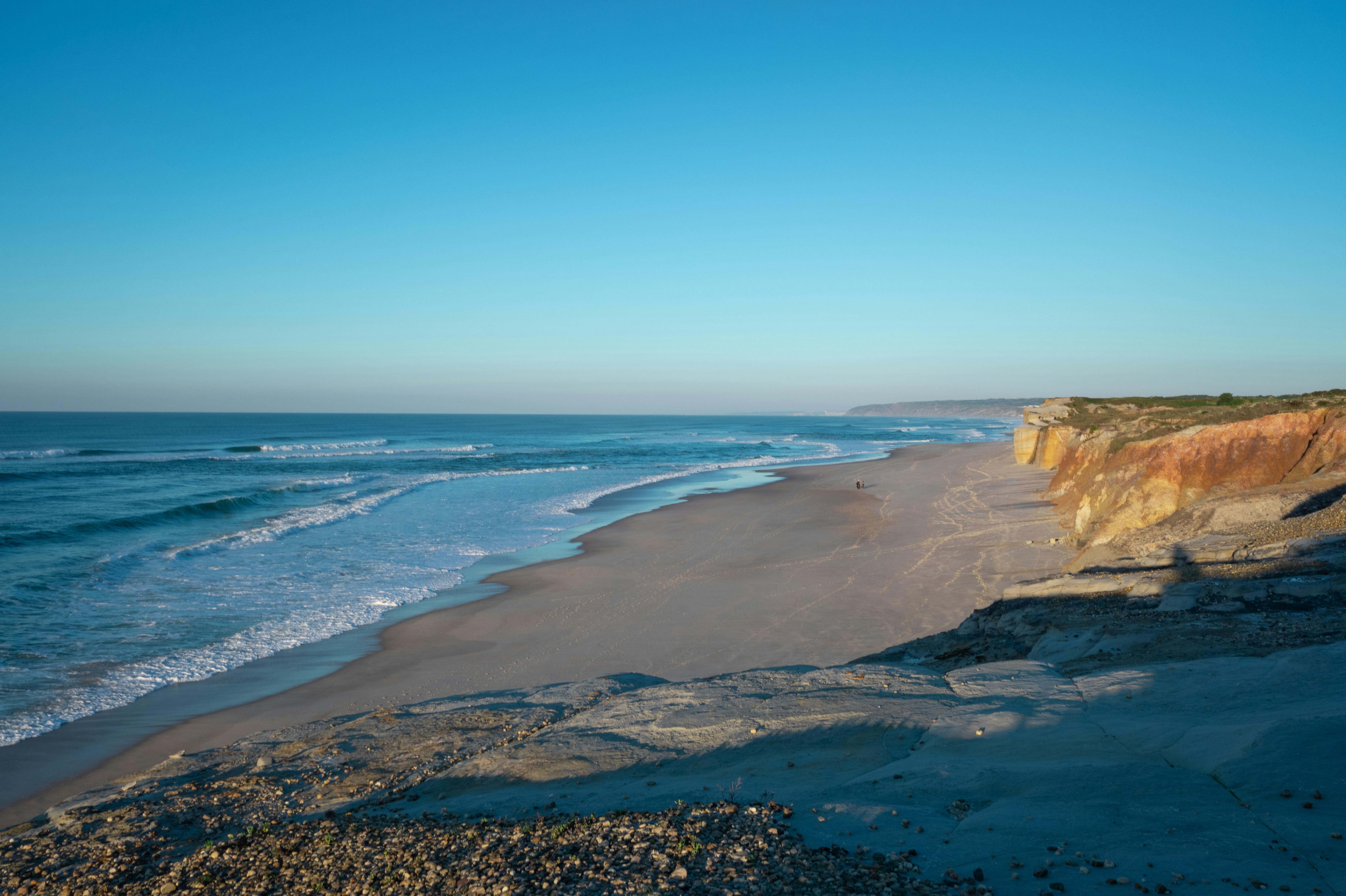 sandy beach under a cliff by the ocean