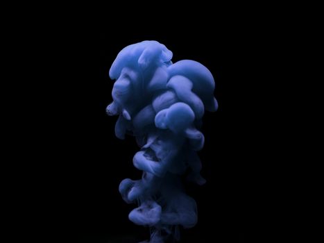 Stunning close-up of blue ink swirling underwater against a dark backdrop, highlighting fluidity and texture.