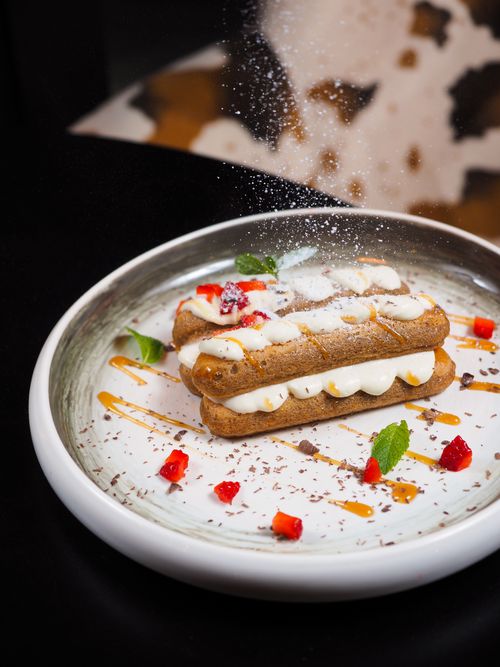 Free Close-up of eclairs topped with creamy filling, sugar, and vibrant garnishes. Stock Photo