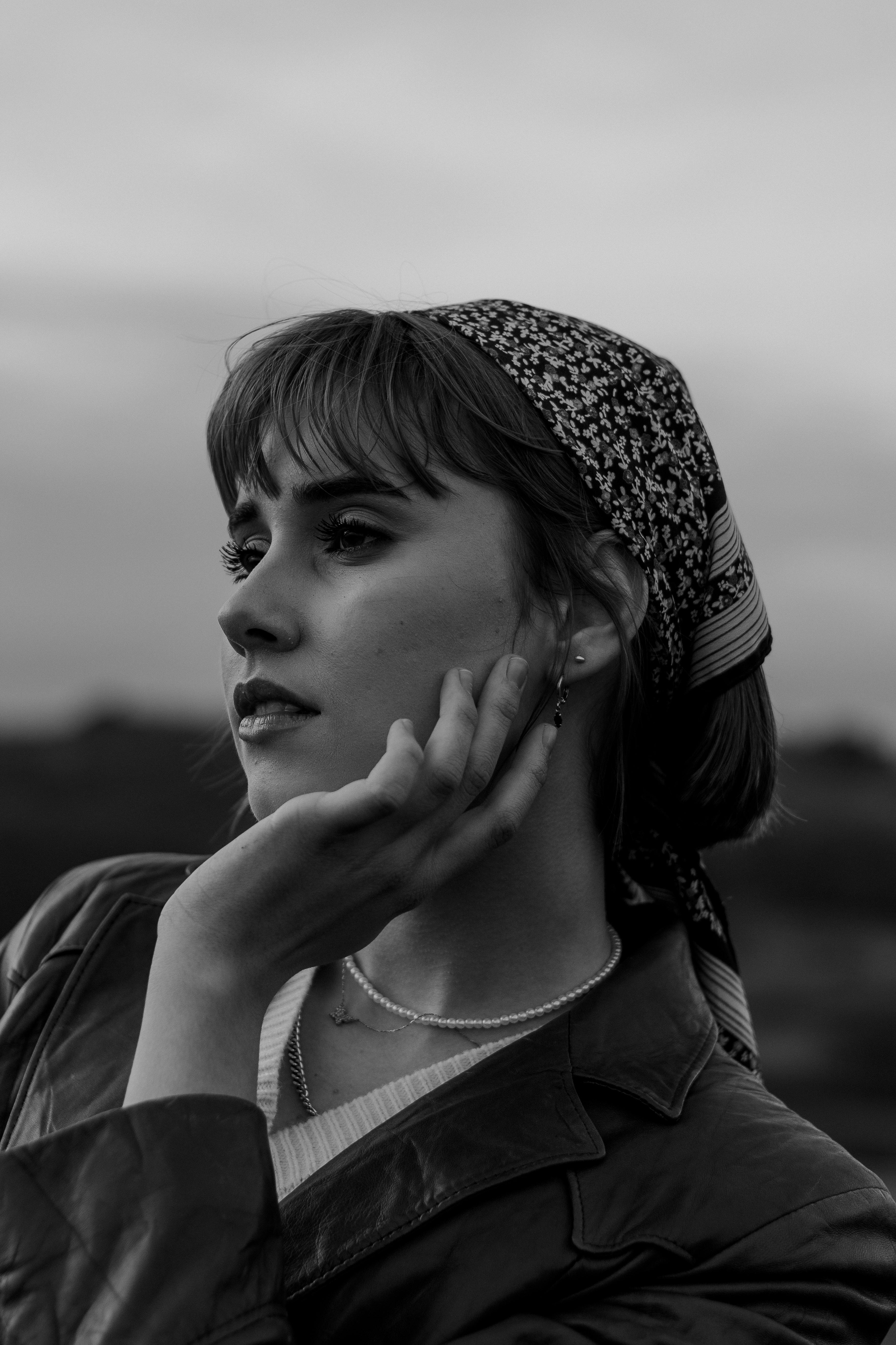 Striking black and white portrait of a woman with a headscarf, exuding elegance and mystery.