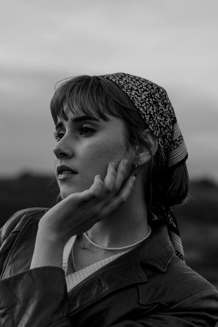 Striking black and white portrait of a woman with a headscarf, exuding elegance and mystery.