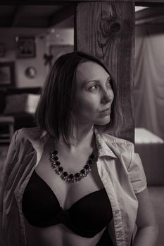 Black and white portrait of a woman in an open shirt and necklace.
