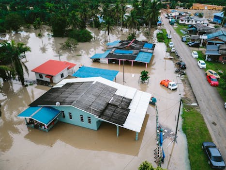 Aerial view of a flooded village in Kijal, Terengganu, Malaysia, showcasing submerged houses and streets.