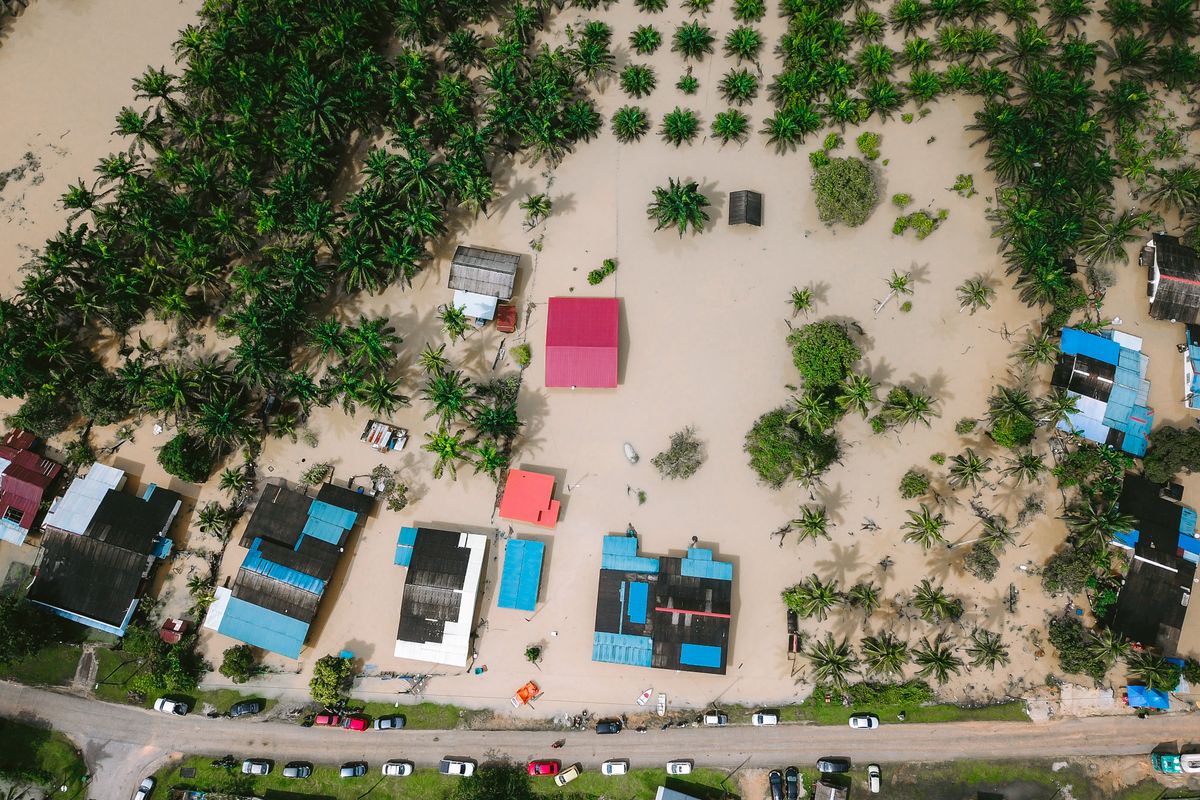 Aerial view of a flooded village in Kijal, Terengganu, Malaysia with submerged houses among palm trees