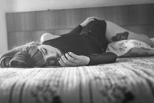 Free Grayscale Photo of Woman Lying on Bed Stock Photo