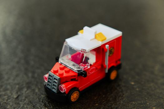 Detailed close-up of a small red toy truck, focusing on design and color.