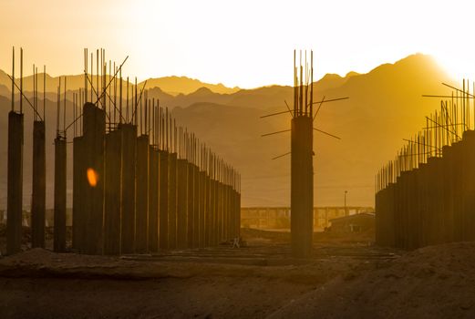 Golden hour at a construction site in Dahab, Egypt with silhouetted mountains in the background.