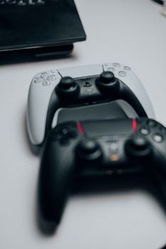 Close-up view of modern game controllers placed on a desk, showcasing design and technology.