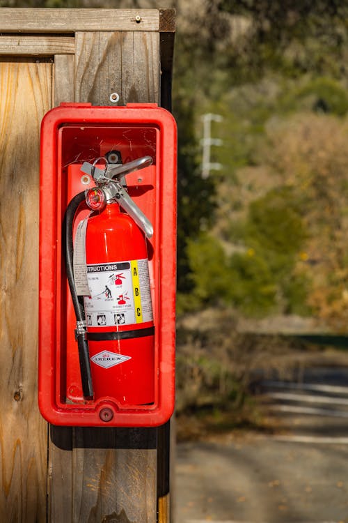 Free A Fire Extinguisher Mounted on a Wooden Post Stock Photo