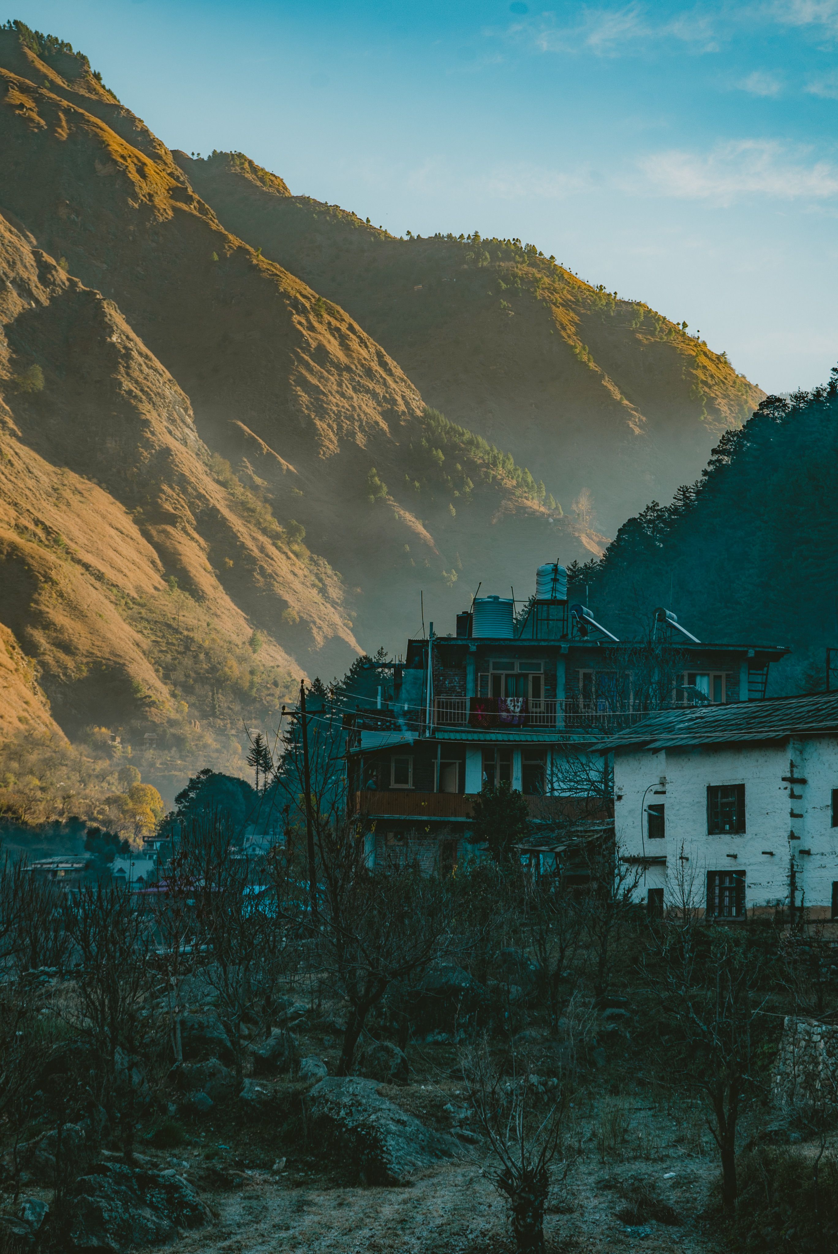 Charming mountain village with rustic houses and dramatic hills at sunrise.