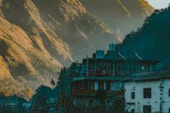 Charming mountain village with rustic houses and dramatic hills at sunrise.