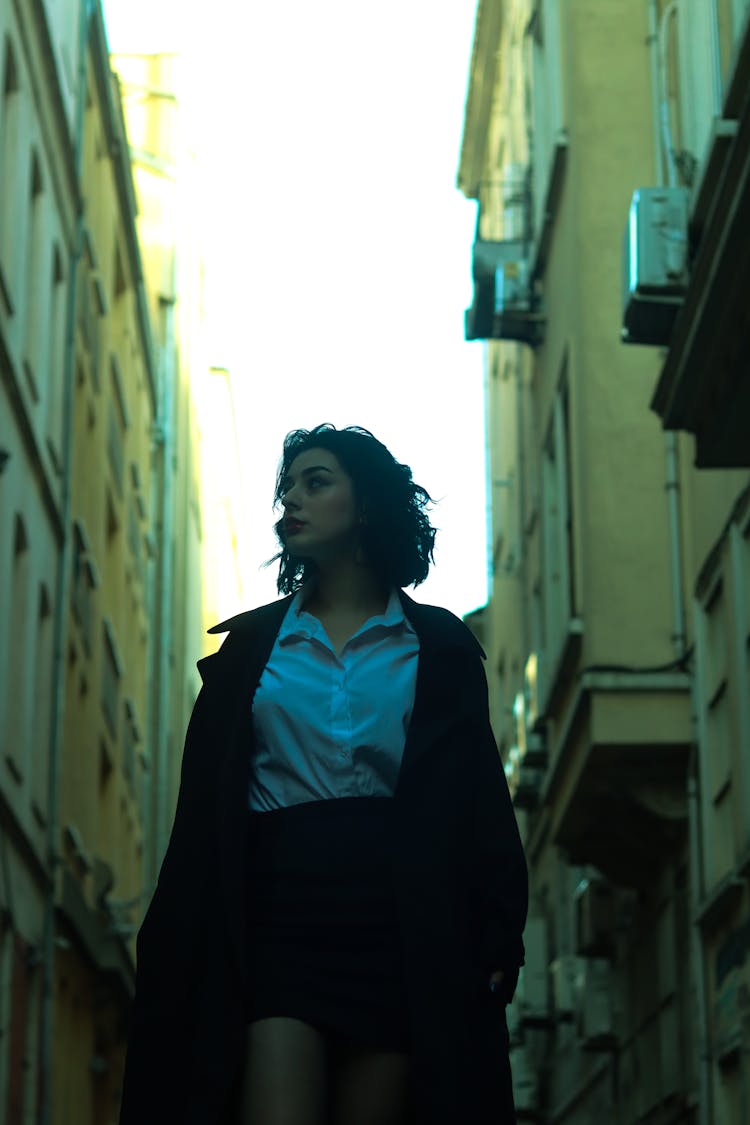 Woman Wearing A Black Coat Walking On The Street While Looking Sideways