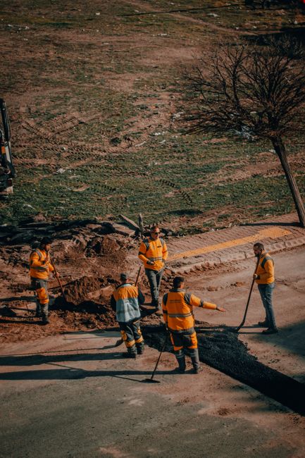 Group of road workers repairing asphalt in Kayseri, Turkey, in a sunny outdoor setting. Group of road workers repairing asphalt in Kayseri, Turkey, in a sunny outdoor setting.