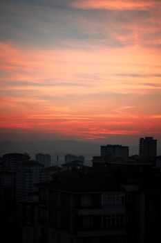 Silhouetted cityscape with a vivid sunrise sky, showcasing serene urban beauty.