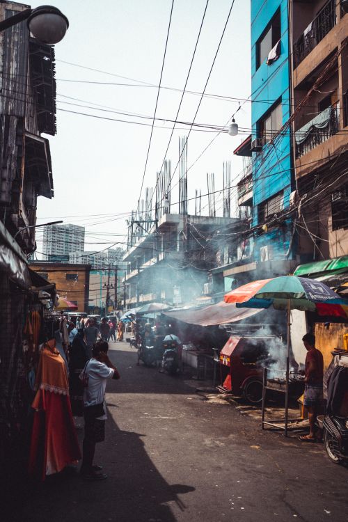 Free A vibrant street scene in Manila's bustling urban area with markets and people. Stock Photo