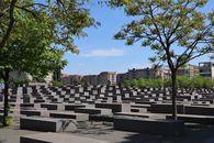 Holocaust Memorial in Berlin, Germany, with trees and clear sky.