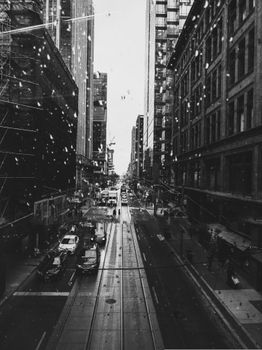 A bustling city street view in black and white with modern architecture.