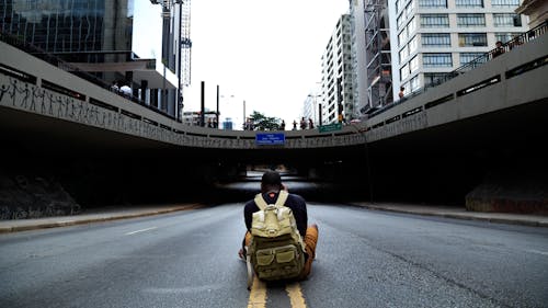 Фотография человека, сидящего посреди дороги