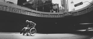 Grayscale Photo of Man on Wheelchair