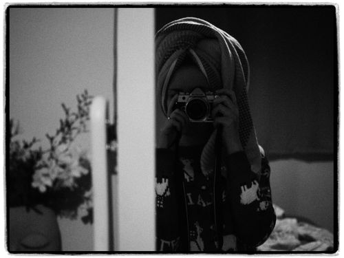 Free Black and white reflection of a woman taking a photo with vintage camera. Stock Photo