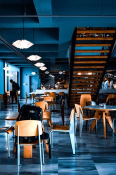 Contemporary café interior with sleek tables, chairs, and unique lighting.