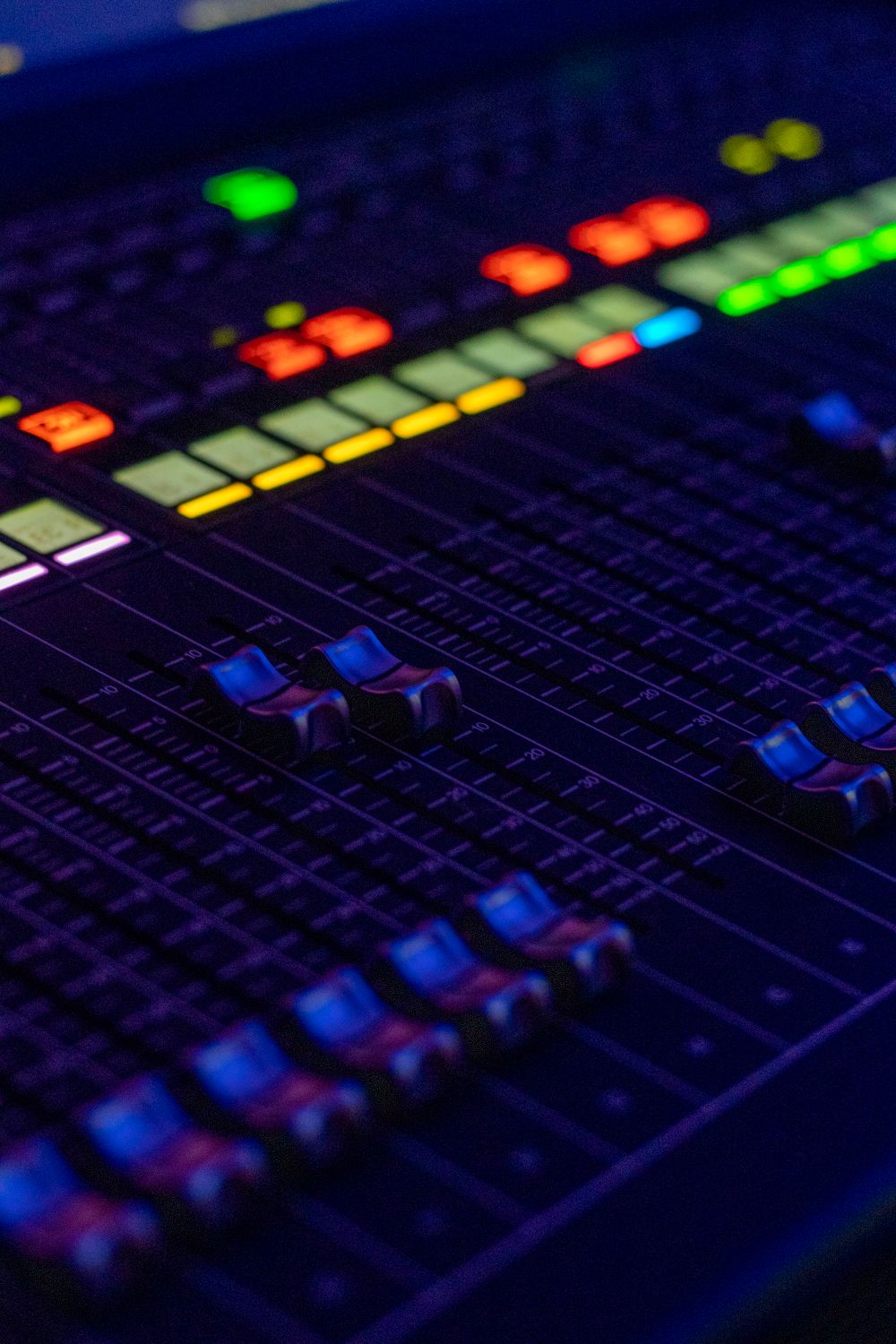 Close-up of a control panel with illuminated faders