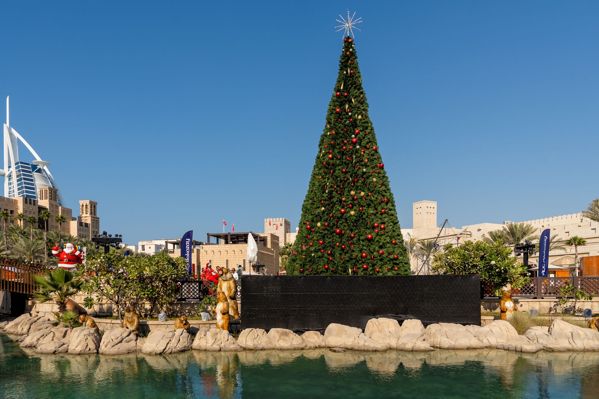 A festive Christmas tree stands tall against the backdrop of Burj Al Arab in Dubai, showcasing holid
