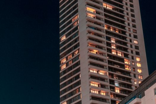 A vibrant view of a skyscraper with glowing windows against a night sky.