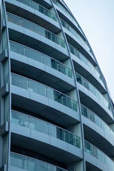 Close-up of a modern residential building with glass balconies, showcasing urban architecture.