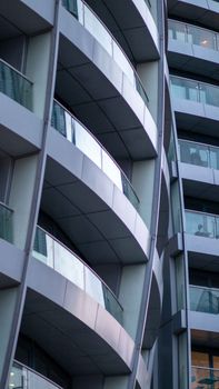 Close-up of a modern building's curved balconies in an urban setting.