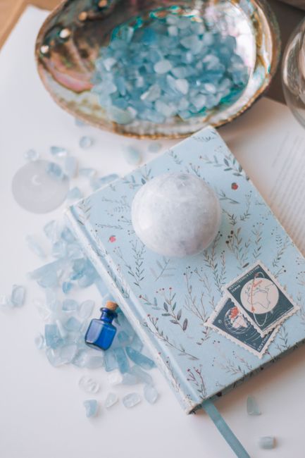 A flat lay composition featuring a crystal adorned notebook with decorative elements, perfect for creative projects.